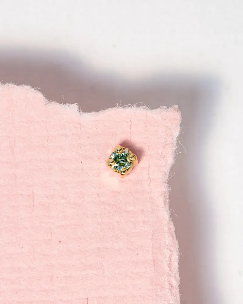 Piercing met mint groene diamant